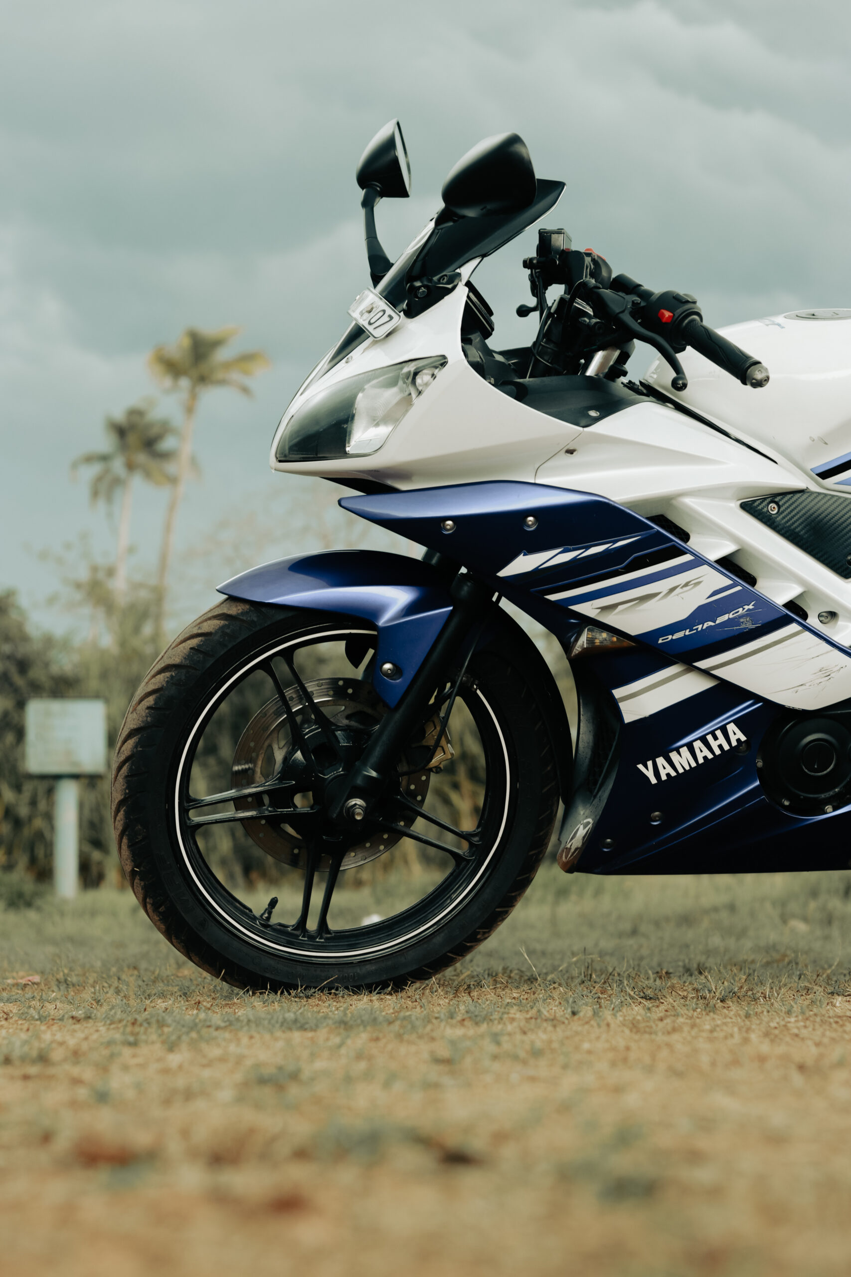 Close-up of a Yamaha sports bike parked on grassy field in Kochi, India.